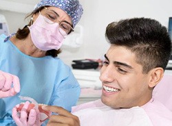 Dentist and patient looking at SureSmile aligner