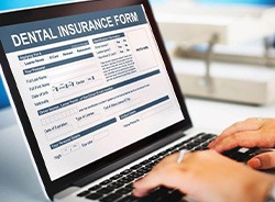 Person filling out dental insurance form on laptop
