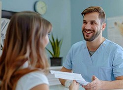 Dental team member interacting with patient at front desk
