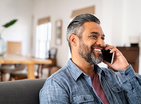 Man smiling while talking on phone
