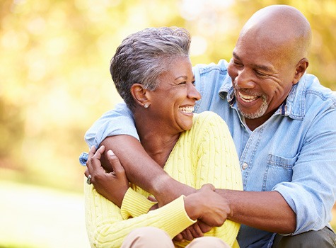 Man and woman outside hugging each other smiling