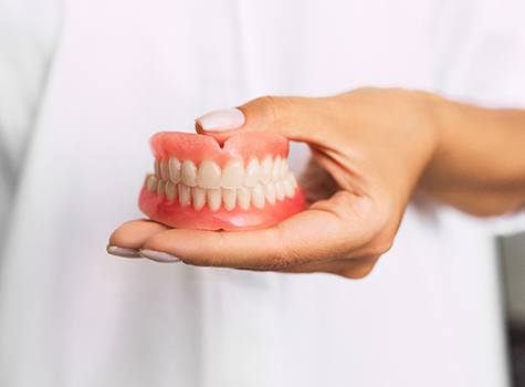 Dentist holding dentures