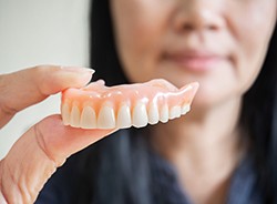 Woman holding a full denture