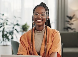 Woman smiling while working on laptop at home